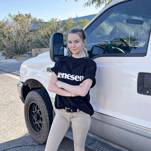Confident young professional in Renesent t-shirt beside white truck